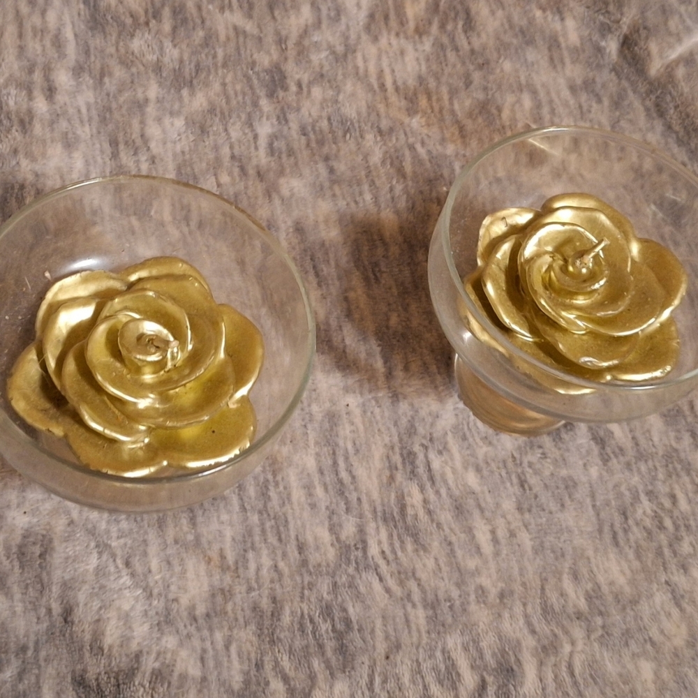 Gold-colored wax rose candles in glass goblets